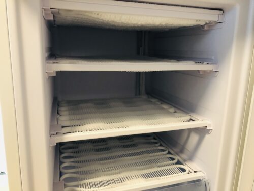小型冷蔵庫のトレーを外したところ。全部の段に霜が薄くついている。